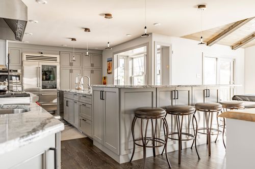 Kitchen with vaulted wood beam ceiling accent, gray cabinets and stainless refrigerator