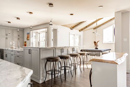 Kitchen dining nook with wood beam ceiling, marble-top table and bar stool seating