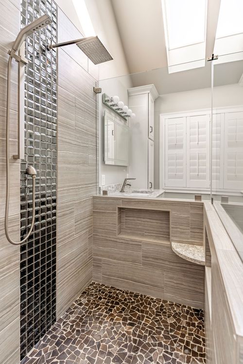 Shower head and mosaic tile column beside a shuttered window