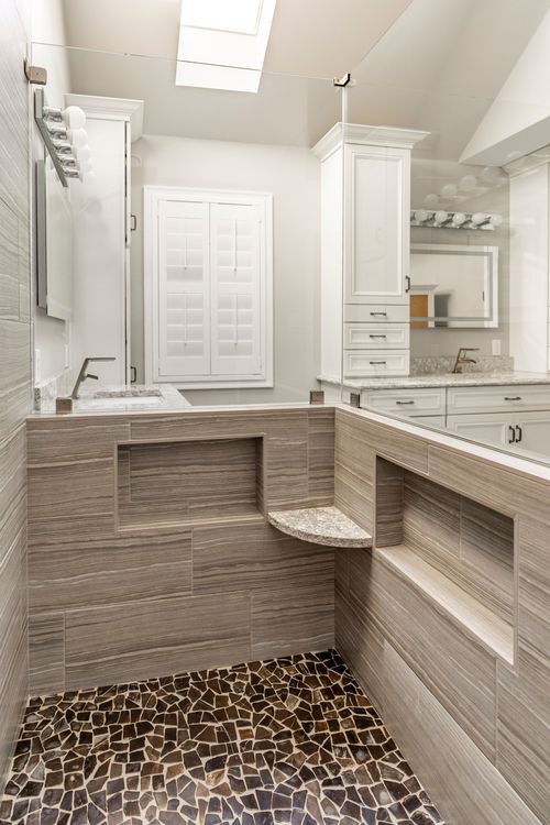 Walk-in shower with built-in bench niche, pebble floor and mosaic tile