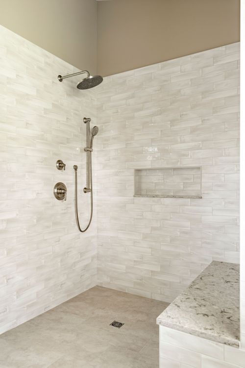 Walk-in shower with rainfall head, subway tile walls and granite bench seat