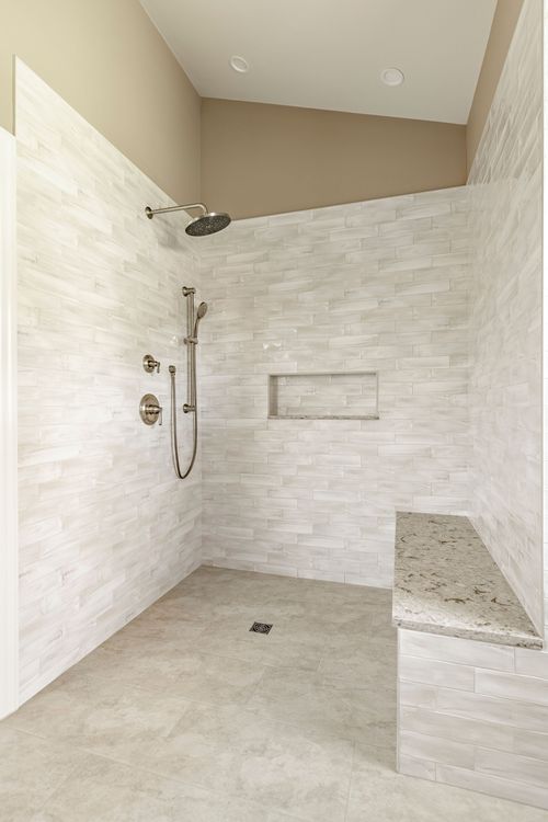 Tiled walk-in shower with rainfall head, storage niche and granite bench