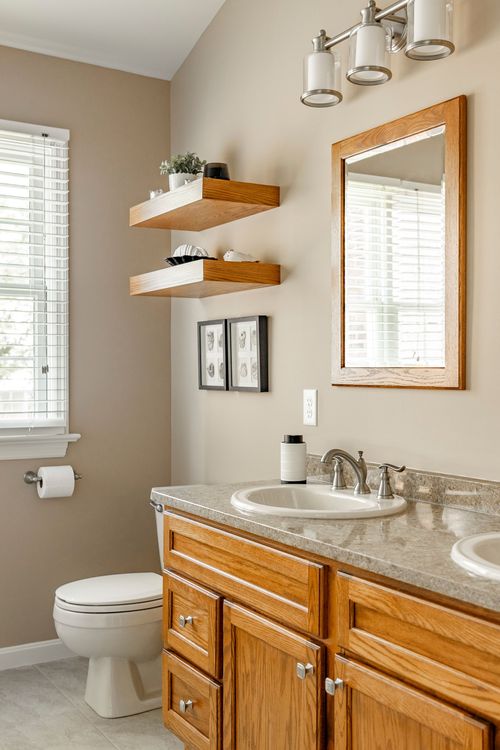 Bathroom with floating wood shelves, oak vanity and wood-framed mirror