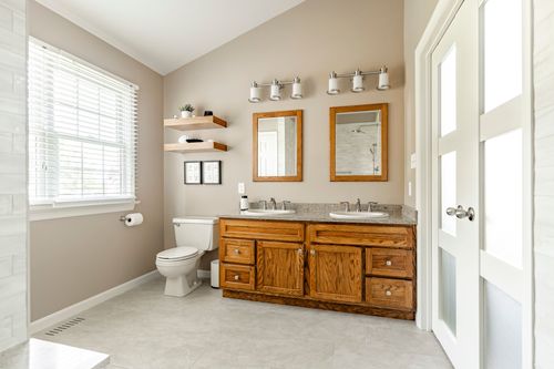 Bathroom with oak double vanity, granite counter and frosted glass double doors