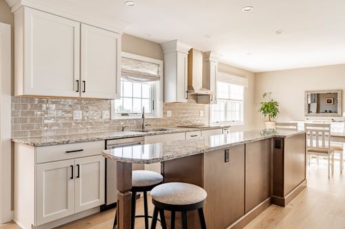 White kitchen with subway tile backsplash, granite counters and island seating