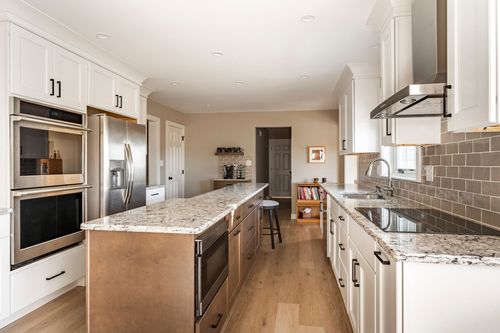 Kitchen island with built-in microwave drawer, granite counter and floating wood shelves