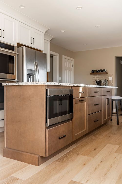 Kitchen with stainless double ovens, subway tile backsplash and wood island