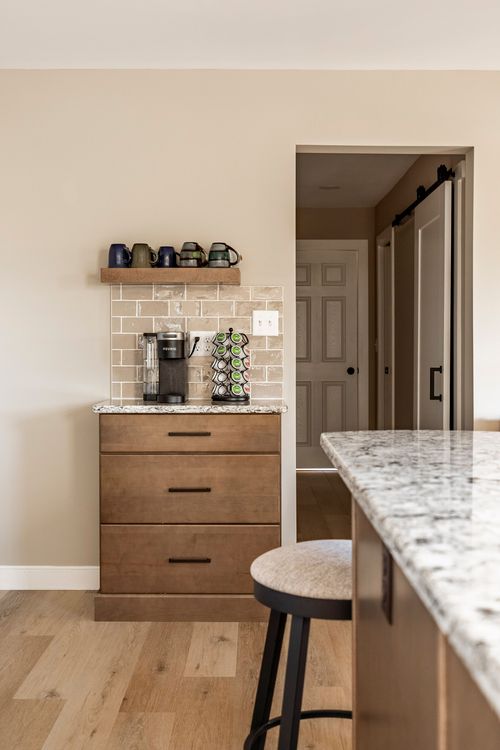 Coffee bar nook with floating mug shelf, tile backsplash and a wood dresser base