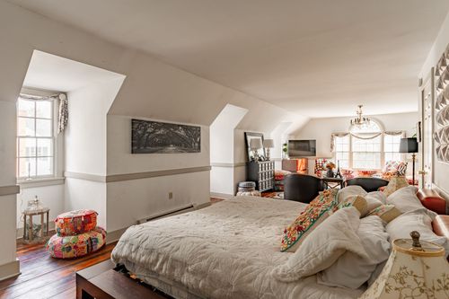 Loft bedroom with vaulted ceiling, colorful pillows and a sitting area