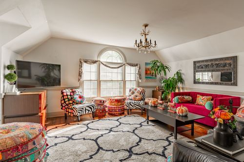 Eclectic living room with a red sofa, zebra print chairs and patterned rug