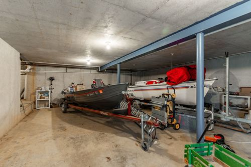 Concrete-floor storage bay with boats parked under exposed steel beams