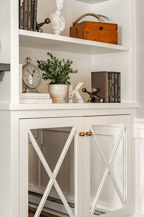 Built-in shelf styled with a marble bust, antique clock and potted greenery