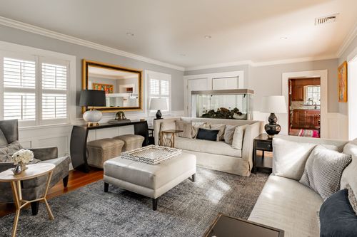 Living room with gilt mirror, console table, fish tank and neutral sectional seating
