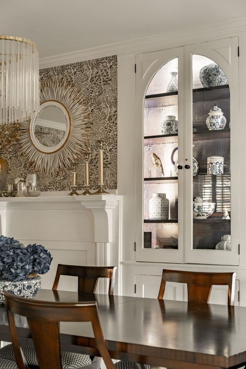 Dining room mantel with sunburst mirror, brass candlesticks and blue hydrangeas