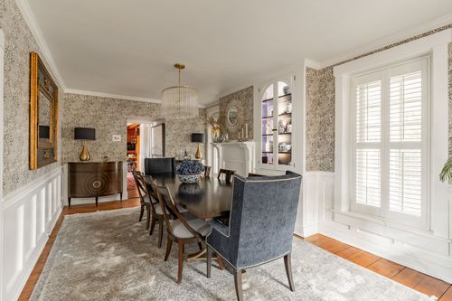 Dining room with gilt sunburst mirror, sideboard and built-in china cabinet