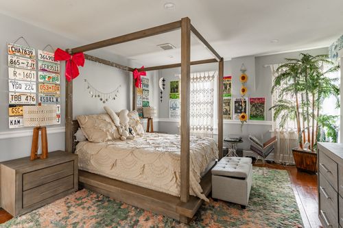 Eclectic bedroom with canopy bed, vintage license plate wall art and colorful accents