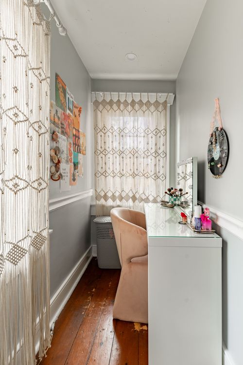 Dressing nook with macrame curtains, a vanity desk and mirror