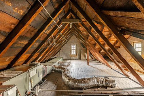 Attic space with exposed wood rafters, plank flooring and ductwork