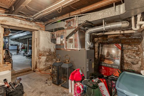 Stone-walled basement with furnace, storage crate and holiday decor