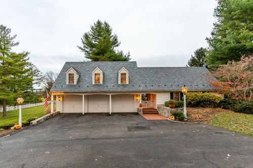 Aerial view of a dormered garage house with brick walkway and flags
