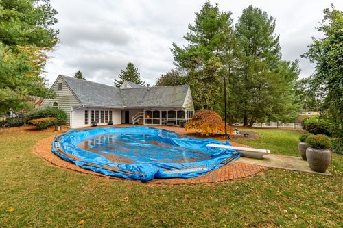 Backyard patio with a covered pool wrapped in a blue tarp