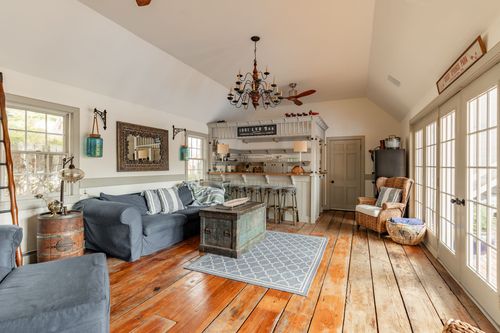 Open living area with vaulted ceiling, blue sectional and built-in wood bar