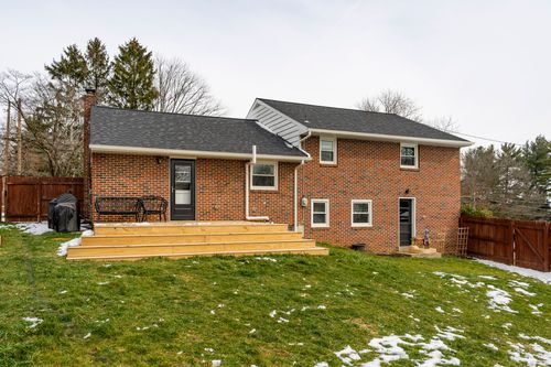 Brick home patio with a new wood deck, bench seating and grill