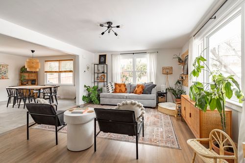 Bright living room with gray sofa, black accent chairs and layered rugs