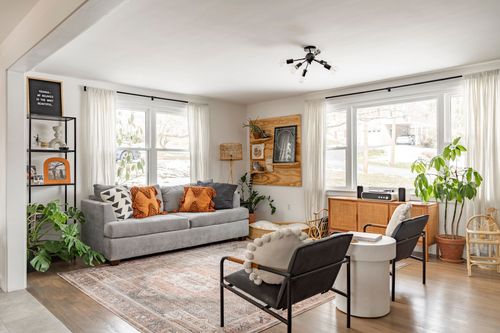 Living room with gray sofa, orange throw pillows and a sputnik ceiling light