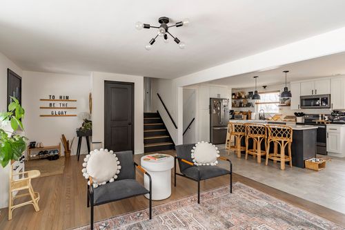 Foyer with black front door, painted staircase and hardwood floors