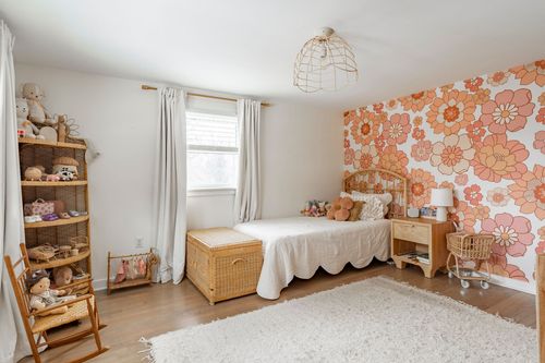 Kids bedroom with floral wallpaper accent wall and woven pendant light