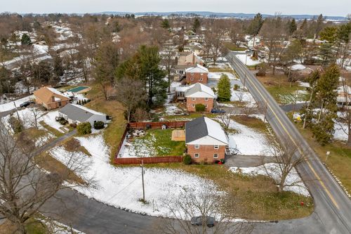 Snow-dusted brick split-level home exterior with attached garage and bare trees