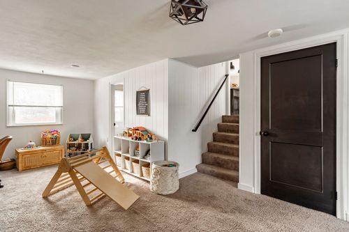 Basement playroom with cubby storage, a balance beam toy and a dark staircase