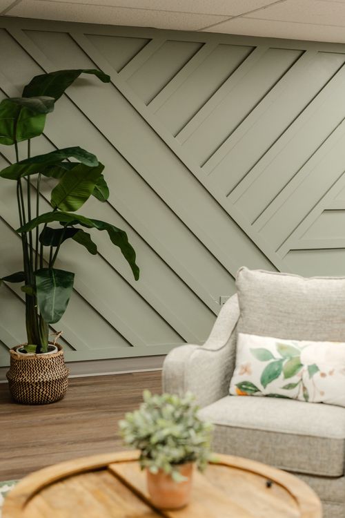 Lounge seating area with a black bookshelf, botanical art prints and neutral swivel chairs
