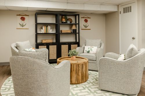 Close-up of a black bookshelf corner styled with books and a botanical art print