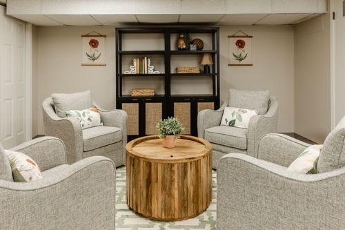 Close-up of a botanical art print above a neutral upholstered lounge chair