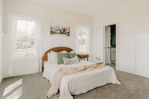 Bedroom with a wood bed and an open door to an ensuite bathroom