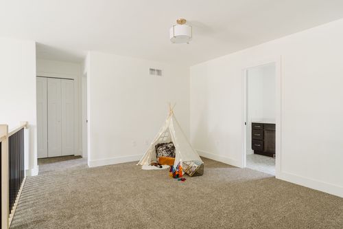 Loft playroom with a play tent and doors to a closet and bathroom