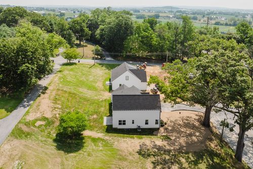 Aerial view of a farmhouse under construction near open farmland