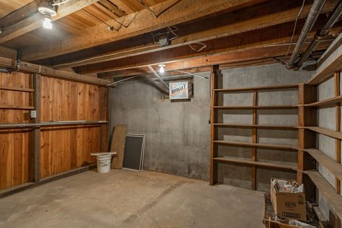 Basement storage room with wood paneling and built-in wood shelving units