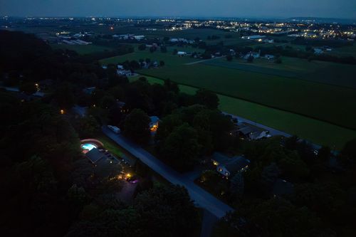 Aerial nighttime view over rural fields and scattered lit homes near the property
