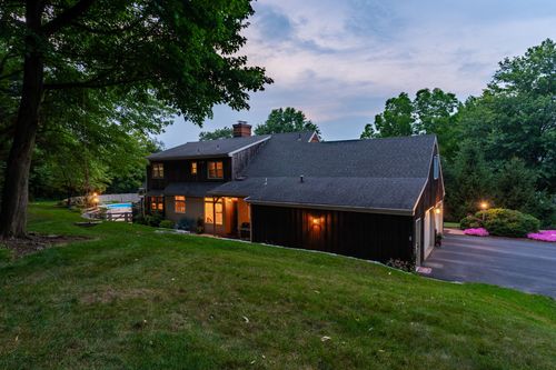 Dusk exterior of a two-story home with attached garage and a paved driveway