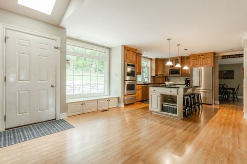 Kitchen with wood cabinets, stainless appliances, and a wine fridge on the island