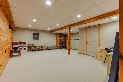 Basement playroom with recessed lighting, wood beam accent, and toy furniture