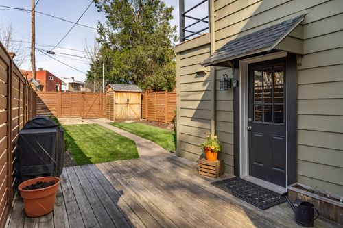 Back door with an awning canopy opening onto a wood deck and fenced backyard