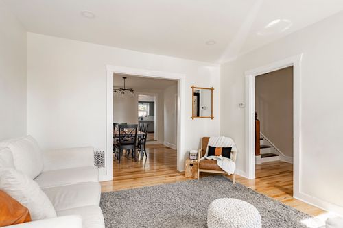 Living room corner with a wood accent chair, throw blanket, and view to the dining area