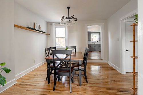 Dining room with a wood table, black X-back chairs, and a sputnik chandelier