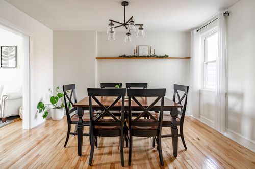 Dining room with a farmhouse table, black chairs, and a modern sputnik light fixture