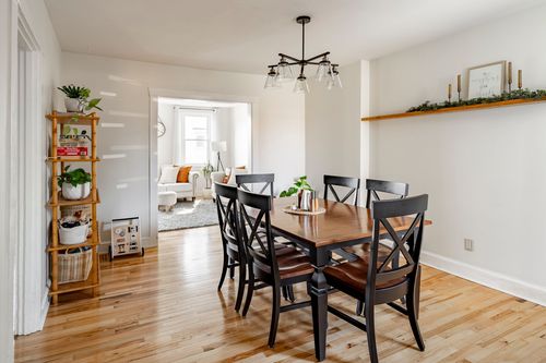 Dining room with a wood table, black chairs, and a bamboo ladder shelf