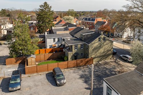 Aerial view of a home with a wood privacy fence and small yard in a dense city block